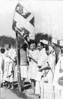 Gandhiji hoisting the Indian flag with the charka at the Lahore session of the Indian National Congress, December 1929.